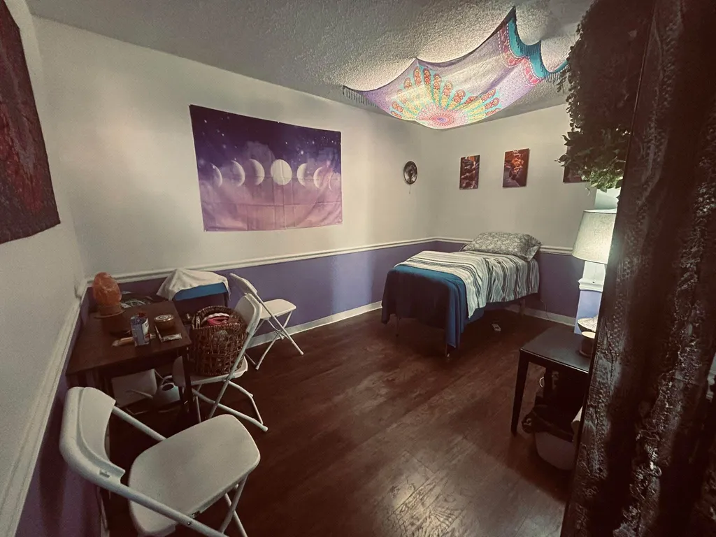 Soul to Sole Sanctuary treatment room with moon-phase tapestry, mandala ceiling, and warm lighting